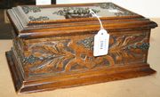 A late Victorian walnut work box with brass mounts and carved decoration.