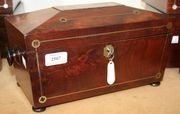 An early 19th Century mahogany sarcophagus tea caddy with brass line inlaid decoration, the sides with turned handles, on bun feet (restoration).