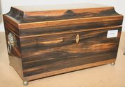 A Regency coromandel tea caddy of sarcophagus form with chequer banded border and gilt paw feet, width approx 31cm.