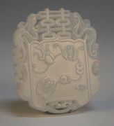 A Chinese white jade pendant, possibly 18th/19th Century, one side carved in low relief with bats and a peach, the other side with a lotus flower, beneath carved and pierced double happiness characters, flanked by a pair of birds, length approx 5.5cm.