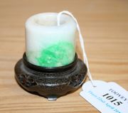 A Chinese jade archers ring, possibly 19th Century, of white/grey tone with green inclusion, diameter approx 3.5cm, together with a carved hardwood stand with silver wire inlay.