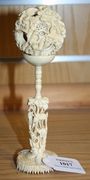 A Chinese Canton carved ivory concentric puzzle ball on stand, early 20th Century, the ball carved in relief with figures, trees and buildings, the stand with a deer amongst foliage, overall height approx 18.5cm.