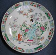 A Japanese 'Famille rose' porcelain charger, early 20th Century, decorated after the Chinese with a maiden and two boy attendants amongst flowers.