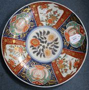 A Japanese Imari porcelain charger, Meiji period, decorated with panels of birds and flowers together with three similar smaller Imari dishes.