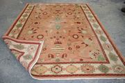 An Afghan carpet, modern, the salmon pink field with bold palmettes and vases of flowers, within an ivory palmette border, approx 344cm x 254cm (cut to border).