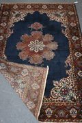 A Kerman rug, South-west Persia, mid-20th Century, the blue field with a lobed medallion, within a deep red palmette border, approx 188cm x 123cm.
