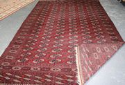 A large Turkestan carpet, early 20th Century, the deep red field with six columns of guls supported by crucifix, within a sunburst gul border, approx 385cm x 235cm.