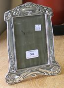 An Art Nouveau silver mounted photograph frame embossed with stylized flowers and tendrils, fitted with leather back and easel stand, Birmingham 1904 by M & Co Ltd, height approx 21cm.