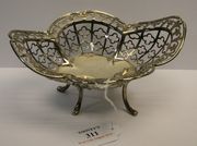 An Edwardian silver bonbon basket of pierced quatrelobed form on four scroll legs, Sheffield 1909 by James Dixon & Sons.