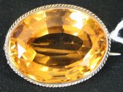 A citrine single stone brooch, mounted with the large oval cut citrine within a twisted wirework surround.