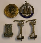 Two blue enamelled 'Dunlop' brooch badges, designed as golfers in an Art Deco design, a sterling and enamelled military brooch badge, detailed 'Dorsetshire', and two further items.