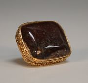 A gold mounted agate vinaigrette, probably Scottish, circa 1830, the gold mounts with cast foliate borders, hinged to reveal a gilt grille pierced and engraved with thistles and leaves, length approx 3.1cm.