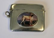 A George V silver vesta case, the front later applied with an oval enamel panel depicting a pug, Birmingham 1910, length approx 5cm.