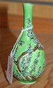 A Chinese enamelled biscuit porcelain green ground bottle vase, late 19th Century, relief decorated with blossoming prunus and a butterfly.