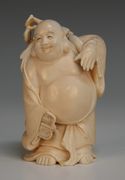 A Japanese carved ivory okimono, Meiji period, of Hotei carrying a bag and a fan, signed to base, height approx 10cm.