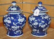 A pair of Chinese blue and white porcelain vases and covers, late 19th Century, each baluster body and domed cover decorated with blossoming prunus branches on a cracked ice ground, height approx 23.5cm.