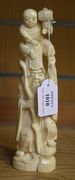 A Japanese carved ivory tusk okimono figure group, Meiji period, in the form of Daikoku, standing with a child on his head holding his mallet, height approx 22.5cm.