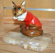 A Royal Doulton fox in hunting dress, designed by Charles Noke, HN100, mounted on a shaped onyx base (glued to base, crack to base of tail).