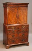 A George I walnut cabinet-on-chest, the moulded pediment above a cushion frieze drawer and two doors enclosing drawers and cupboard, the base with ebony stringing, fitted with two short and three graduated long drawers on bracket feet, height approx 174cm, width approx 92cm (alterations and restoration).