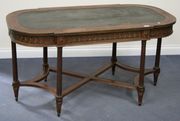 A 19th Century Louis XVI style mahogany and gilt metal mounted centre table, the shaped top inset with tooled green leather above a frieze applied with a beaded and guilloche band, raised on stop fluted legs united by a shaped platform stretcher, length approx 138cm.