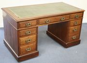 A late Victorian mahogany twin pedestal desk, the top inset with gilt-tooled green leather above an arrangement of nine drawers, on a plinth base and castors, width approx 137cm.