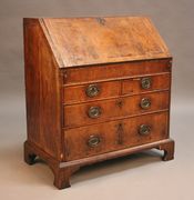 A George I walnut bureau, the fall front revealing a fitted interior of pigeon holes, drawers and a well, above an arrangement of two short and two long drawers, on bracket feet, width approx 86cm (alterations and restoration).
