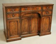 A George III figured mahogany sideboard inlaid with ebony stringing and leaf sprays, the crossbanded top above an arrangement of five drawers and a concealed drawer, the central kneehole cupboard enclosed by two fielded panel doors flanked by two further doors, on a plinth base, height approx 94.5cm, width approx 138cm, depth approx 57cm.