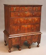 A George I walnut chest-on-stand with herringbone banding, fitted with three short and three long drawers, the stand fitted with three further short drawers above a shaped apron, on bun feet, width approx 102cm (alterations and restoration).