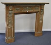 An Edwardian Neoclassical Revival pine fire surround, the moulded top with cast composition acanthus and stiff leaf bands above a frieze cast with panels of fruit-charged urns, flanked by stop fluted and panelled supports, width approx 183cm.