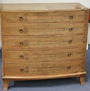 A George V walnut bowfront chest with box stringing, fitted with five graduated long drawers, on bracket feet, together with a similar bedside chest of three drawers.