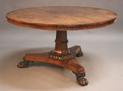 An early Victorian rosewood circular loo table on a flared octagonal column terminating in a carved tulip cusp band, the triform base supported by carved claw feet, height approx 71cm, diameter approx 133cm.