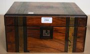 A Victorian rosewood writing slope with brass, ebony and satinwood inlaid decoration, the hinged lid revealing a fitted interior with two secret drawers (faults).