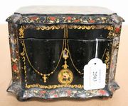 A Victorian black papier-mâché tea caddy with gilded and painted decoration, the hinged lid revealing two compartments and covers, width approx 14cm. 