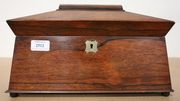 A Regency rosewood sarcophagus tea caddy, fitted with two lidded compartments, on circular feet (faults).