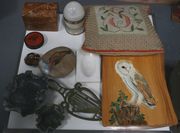A 19th Century black papier-mâché circular snuff box, the cover printed with a soldier holding a rifle, together with a John Sisley needlework cushion, worked with the initial 'S', three soapstone lily pad dishes and sundry collectors' items.