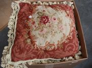 A set of four needlework cushions, worked in wool with flowers and backed in velour.