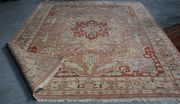 A Turkish carpet, mid/late 20th Century, the beige field with a lobed geometric medallion, within a palmette and vine border, approx 338cm x 276cm.