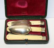 A late 19th Century ivory and plated travelling cutlery set comprising a folding knife, fork and spoon, within a green leather case.