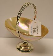 An Edwardian silver mounted mother-of-pearl shell bonbon dish with swing handle on a circular pedestal foot, Birmingham 1907.