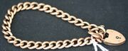 A gold curblink bracelet, with a 9ct gold heart shaped padlock clasp.