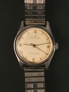 A Rolex Oyster circular steel cased gentleman's wristwatch, the signed silvered dial with gilt Arabic and dot numerals, centre seconds and plain hands, the dial detailed 'Rolex Oyster Shock Resisting', with a milled screw-off case back, numbered between the lugs '358277', the winding button detailed 'Rolex Oyster', on a later expanding metal bracelet, with spare links and a receipt dated 1st May 1947.