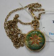 A gold cased, rose diamond set and enamelled keyless wind open-faced lady's fob watch, with an unsigned gilt cylinder movement, gold inner case, the enamelled dial with black Arabic numerals and blued steel hands, the case back with a rose diamond set floral motif, on an enamelled ground, with a 9ct gold oval link neckchain on a boltring clasp.
