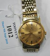 An Omega Automatic gold cased gentleman's wristwatch, the signed dial with baton numerals, date-of-the-month aperture and centre seconds, on a gilt metal bracelet with an Omega fold-over clasp.