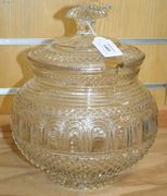A cut glass punch bowl and cover, probably French, late 19th Century, the globular body densely cut with a band of arched panels above strawberry diamonds, the cover with radial cut knop, height approx 28cm.