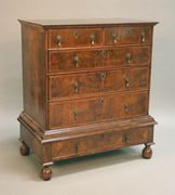 An 18th Century walnut chest-on-stand with cross and featherbanded decoration, fitted with two short and three long drawers, the base fitted with one long drawer, on bun feet (alterations and restoration).