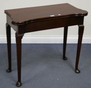 An 18th Century mahogany fold-over tea table fitted with a single drawer, raised on turned tapering legs with pad feet.