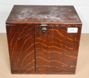 A late Victorian oak table top cabinet, fitted with two hinged doors revealing two drawers.