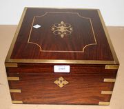 A 20th Century rosewood and brass bound box, the hinged lid enclosing two hinged compartments.