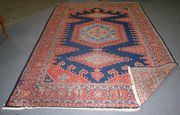 A Hamadan carpet, North-west Persia, early/mid-20th Century, the blue field with three hooked medallions, within a palmette and flowerhead border, approx 330cm x 217cm.