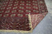 A Pakistan bokhara carpet, mid-20th Century, the red field with six columns of twelve guls, within a sunburst gul border, approx 347cm x 247cm.